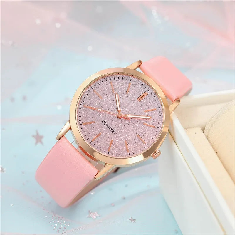 Women's pink quartz watch set with faux leather strap and bracelet on a light background
