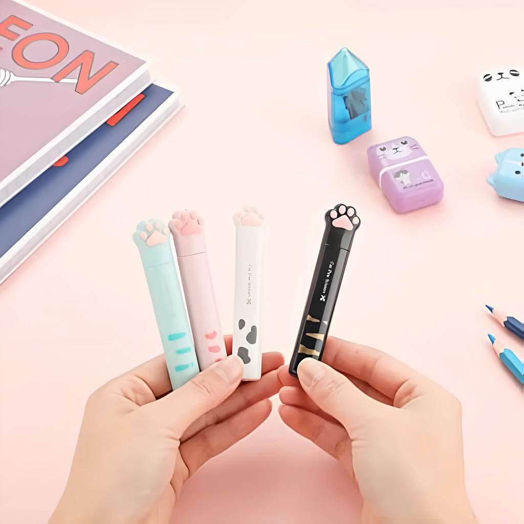Small stainless steel folding scissors with cat paw handles shown in pink, blue, black, and white.