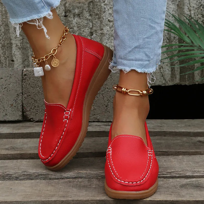 Women's flat slip-on loafers in PU leather with car suture detail, shown in multiple colours.