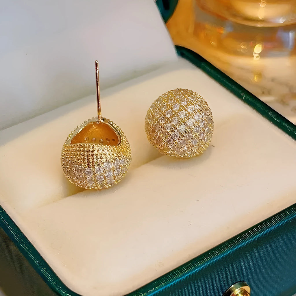 Drop-shaped geometric golden beans and diamond ear clip earrings in gold and white colours.