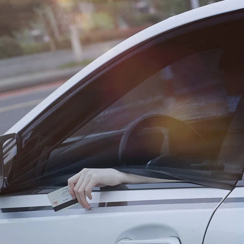 Set of grey non-woven fabric car side window sunshades with elastic edges on a car window.