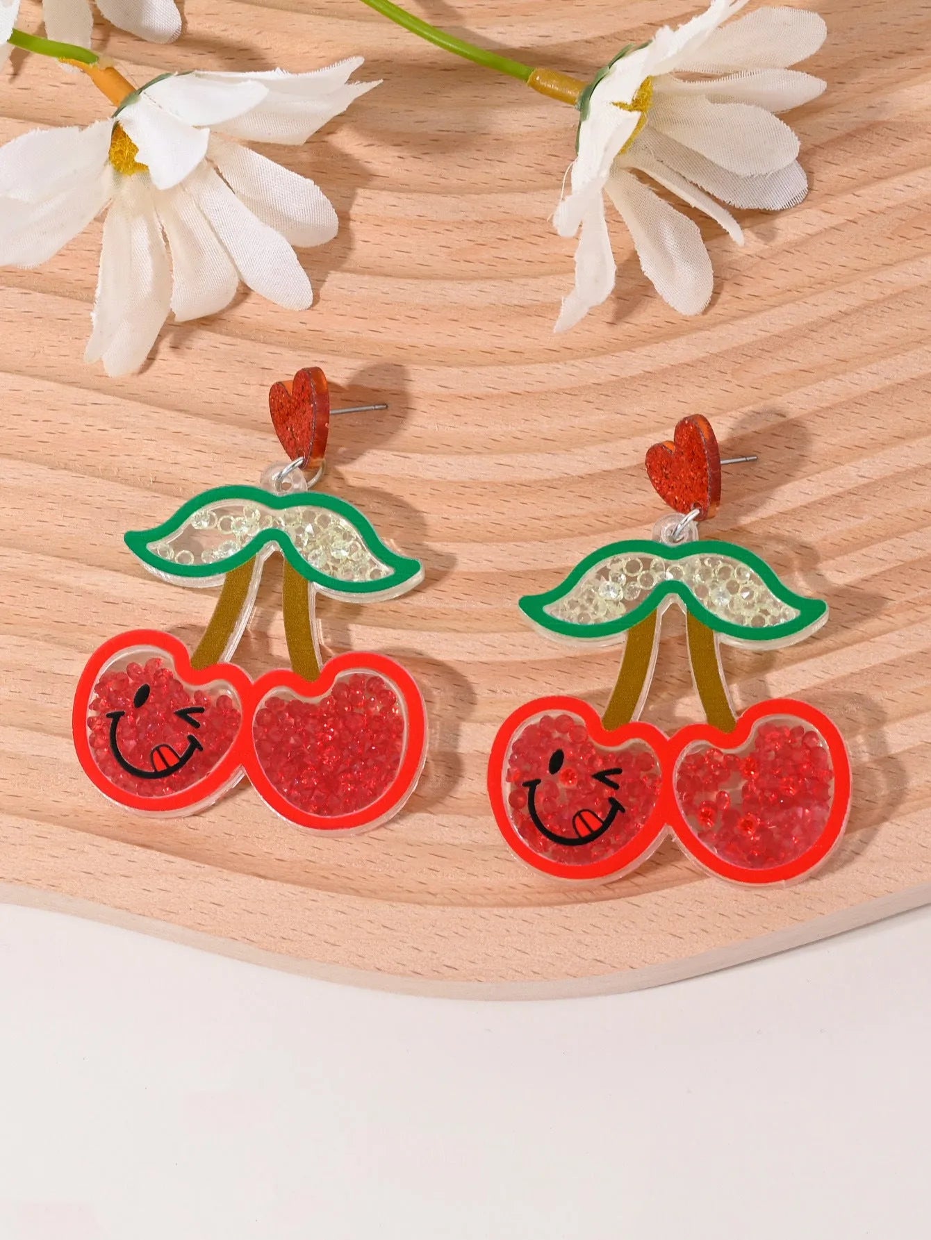 Colourful acrylic earrings with fruit and dessert designs including cherry, strawberry and watermelon shapes