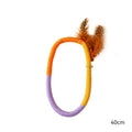 Green circular cotton rope cat toy with white feathers and catnip for chewing and play