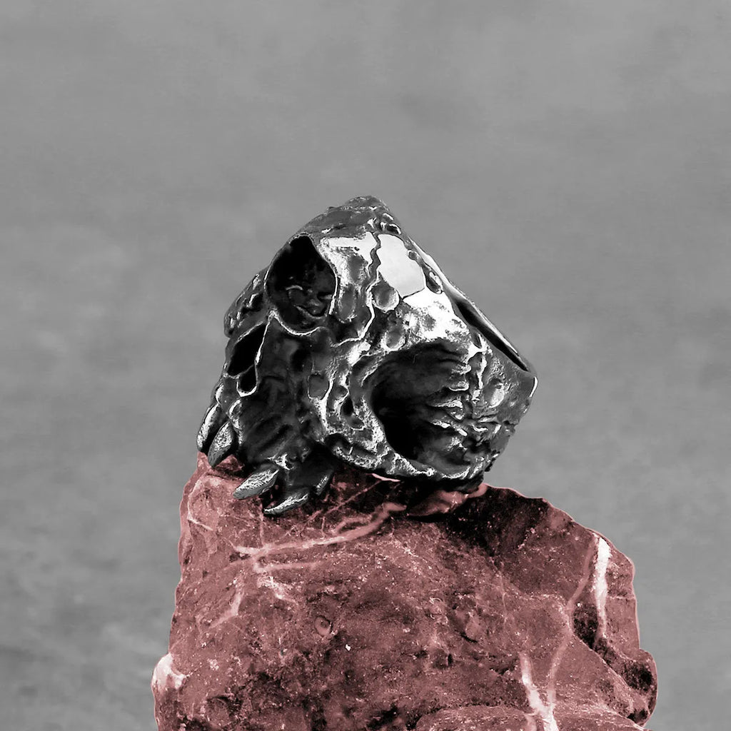 Alloy one-eyed skull ring in retro punk style on a black background.