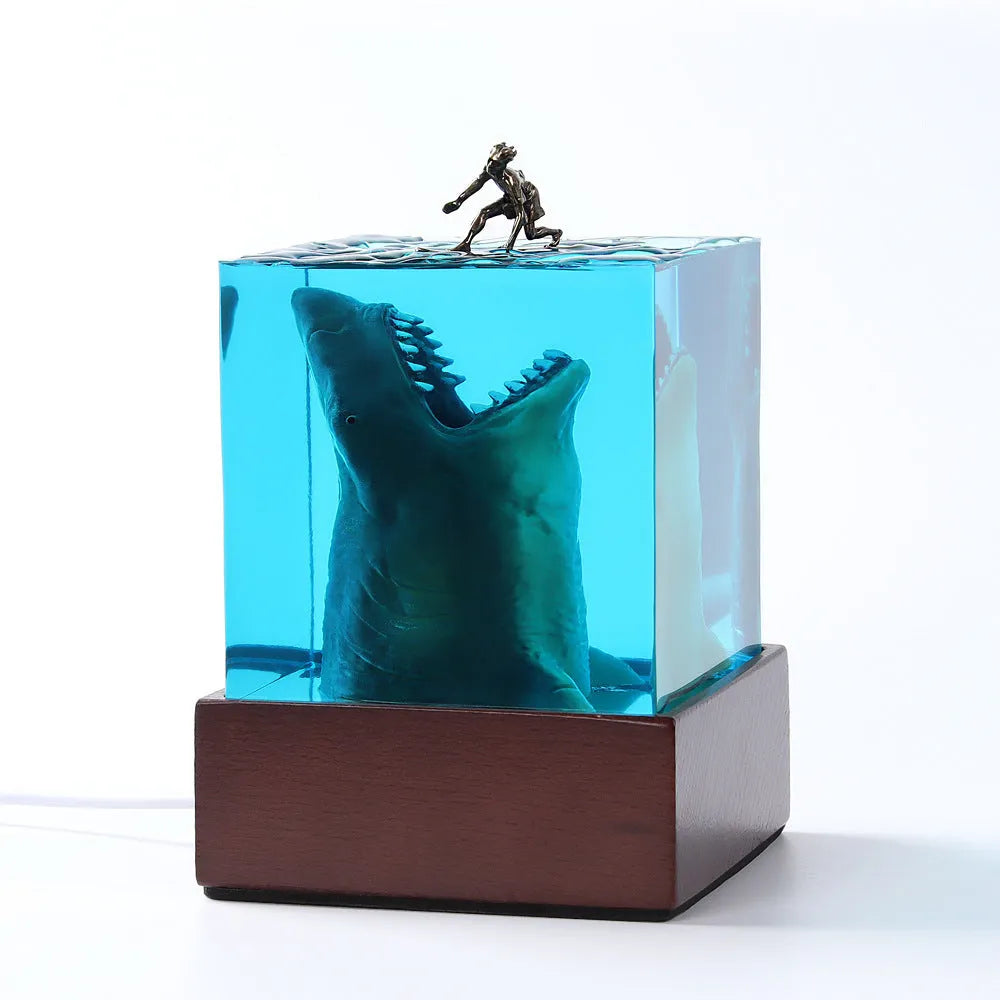 Epoxy resin shark surfer night light ornament on a desk with glowing micro landscape.