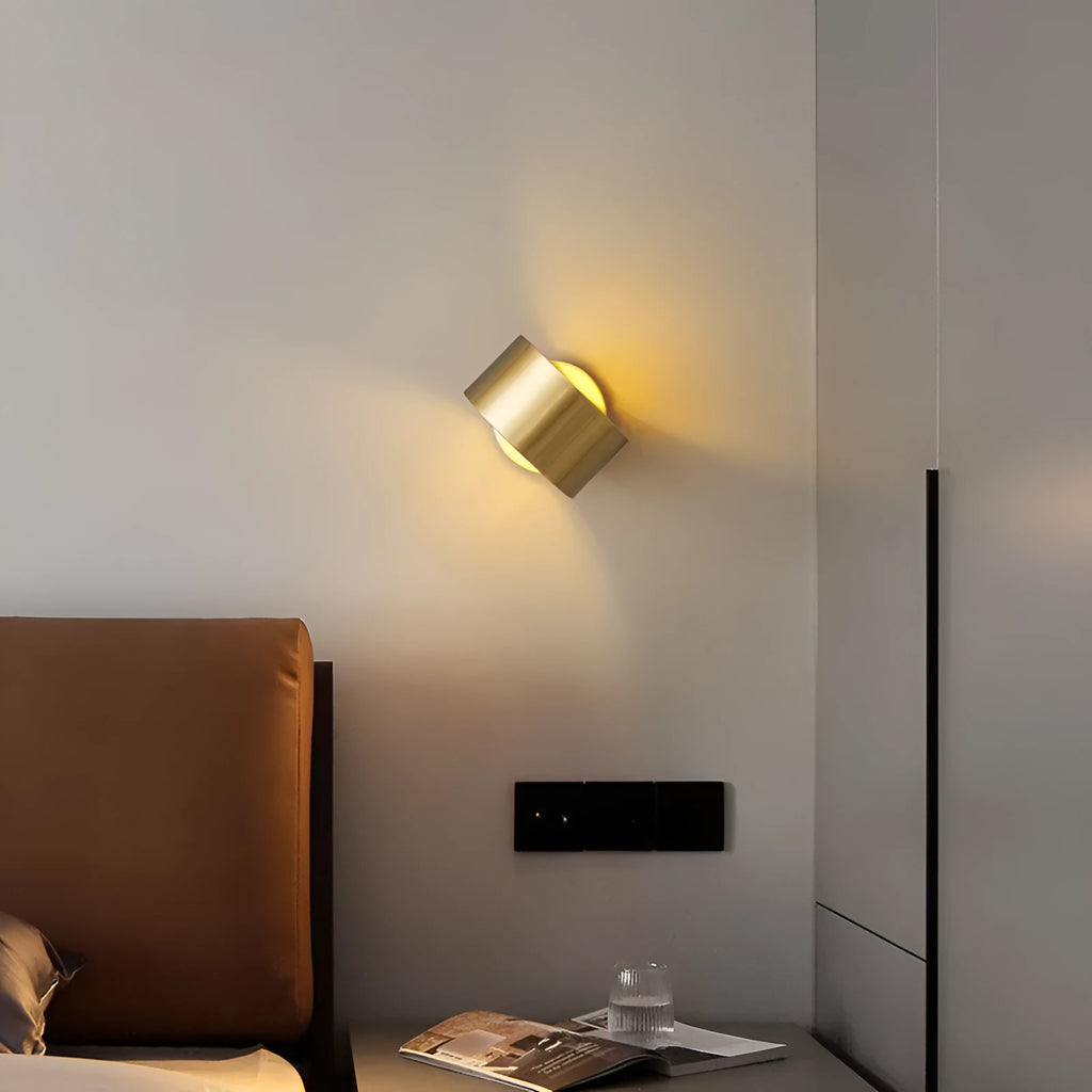 Modern copper wall light fixture in gold finish mounted on a wall