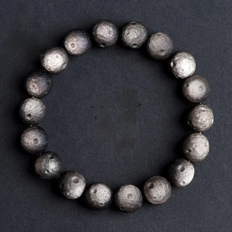 Obsidian crater ball bracelet with textured meteorite-like beads on elasticated cord