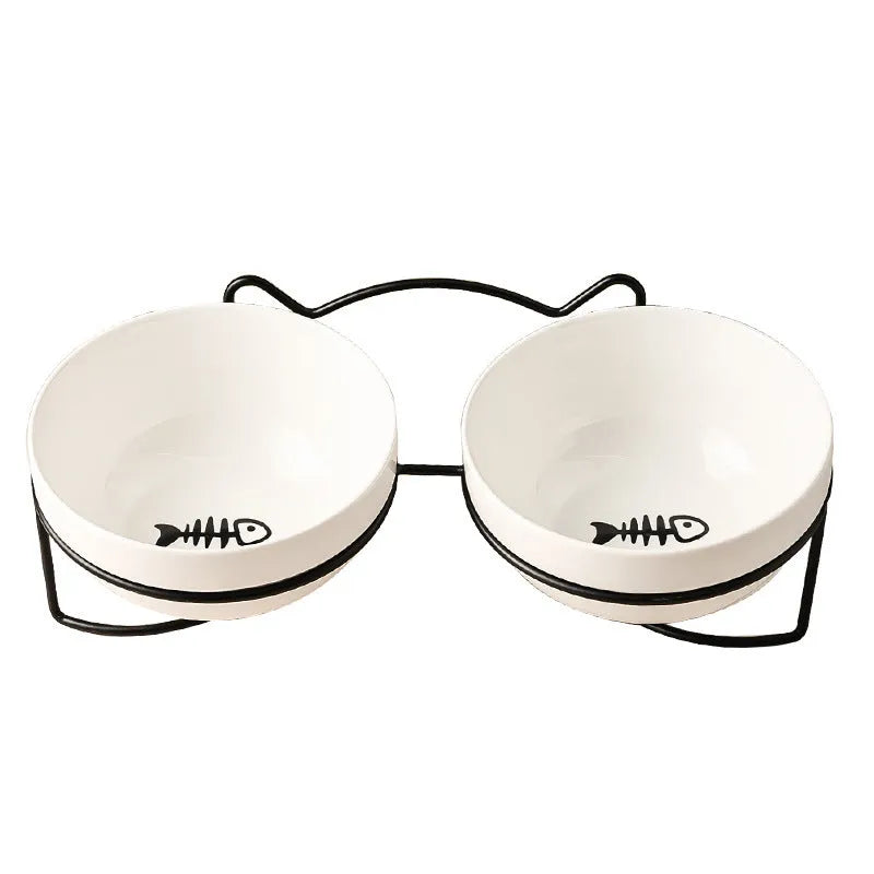 White ceramic pet bowl with cat footprints design in a black iron frame.