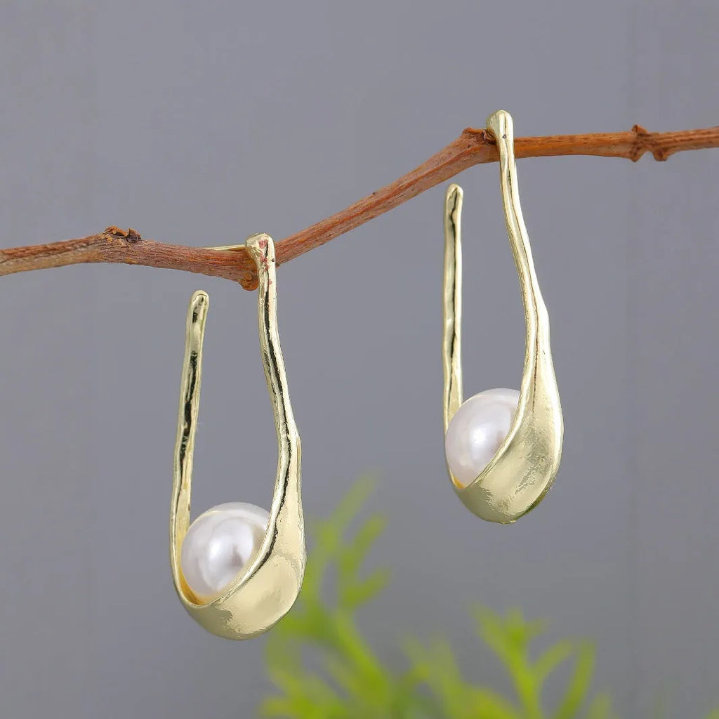 Gold-tone hook earrings with an irregular natural pearl in a vintage European style