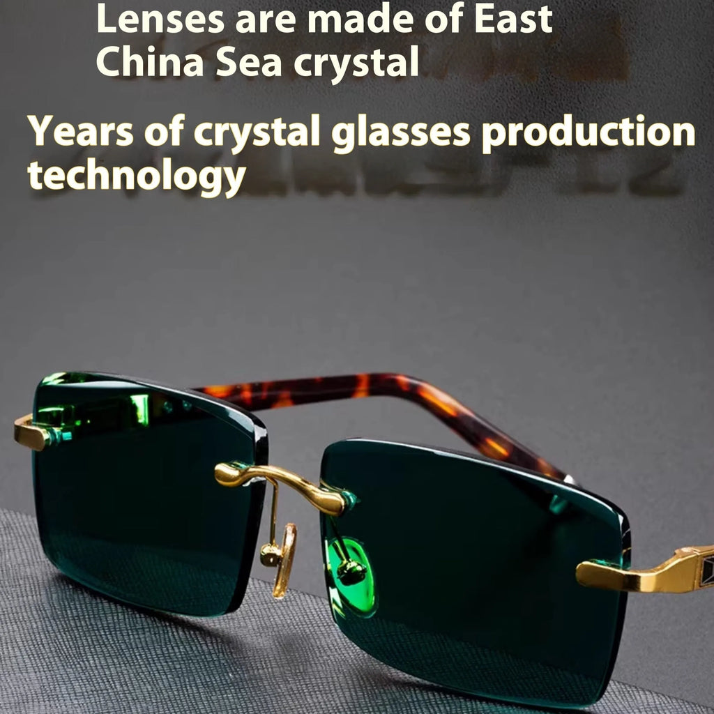 A pair of dark green frameless crystal sunglasses with a gold-tone temple arm on a case.