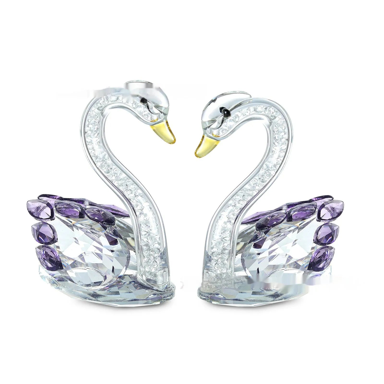 White crystal swan decoration on a desktop in solid head and empty tube styles.
