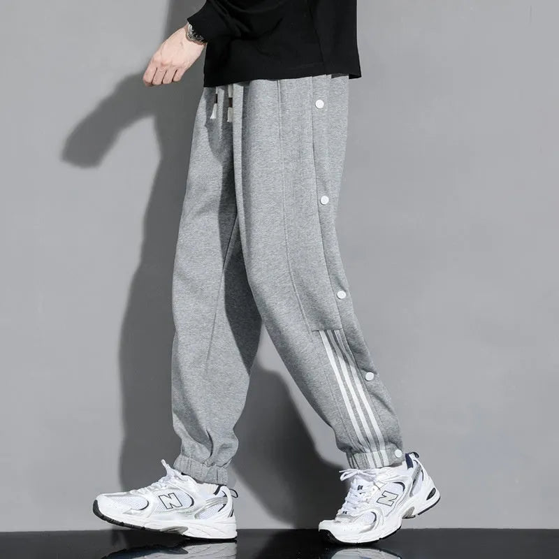 Man wearing loose grey sweatpants with ankle ties and a high waist.