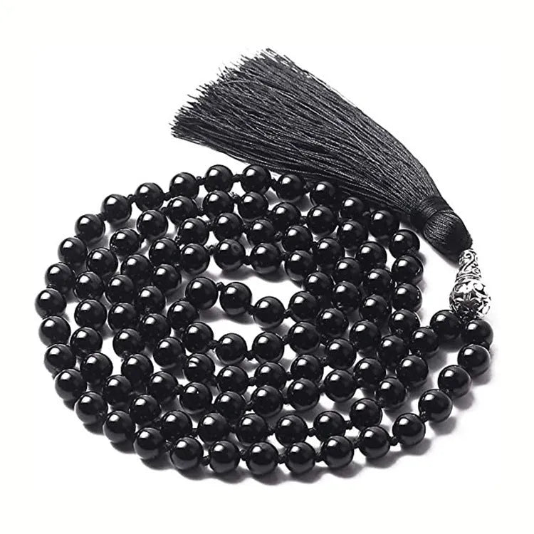 Long geometric agate and gemstone tassel necklace with blue, purple, and multi-coloured beads on a black background.