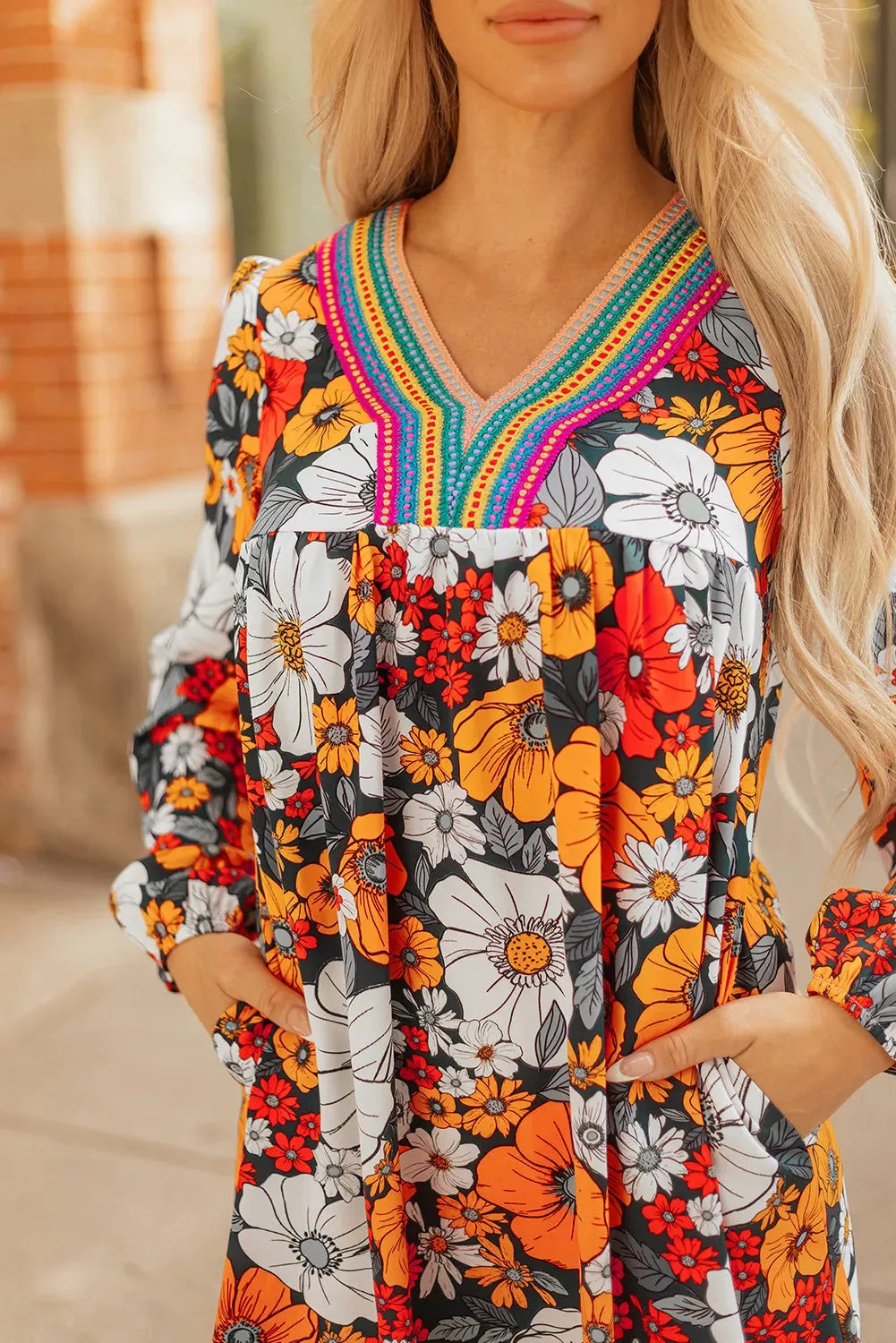 Orange floral print women's mini dress with V neck, long sleeves, and striped lace detail.