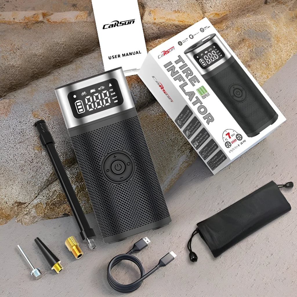 Black portable wireless car air pump with a digital display, inflation hose, and a set of nozzles on a black background.