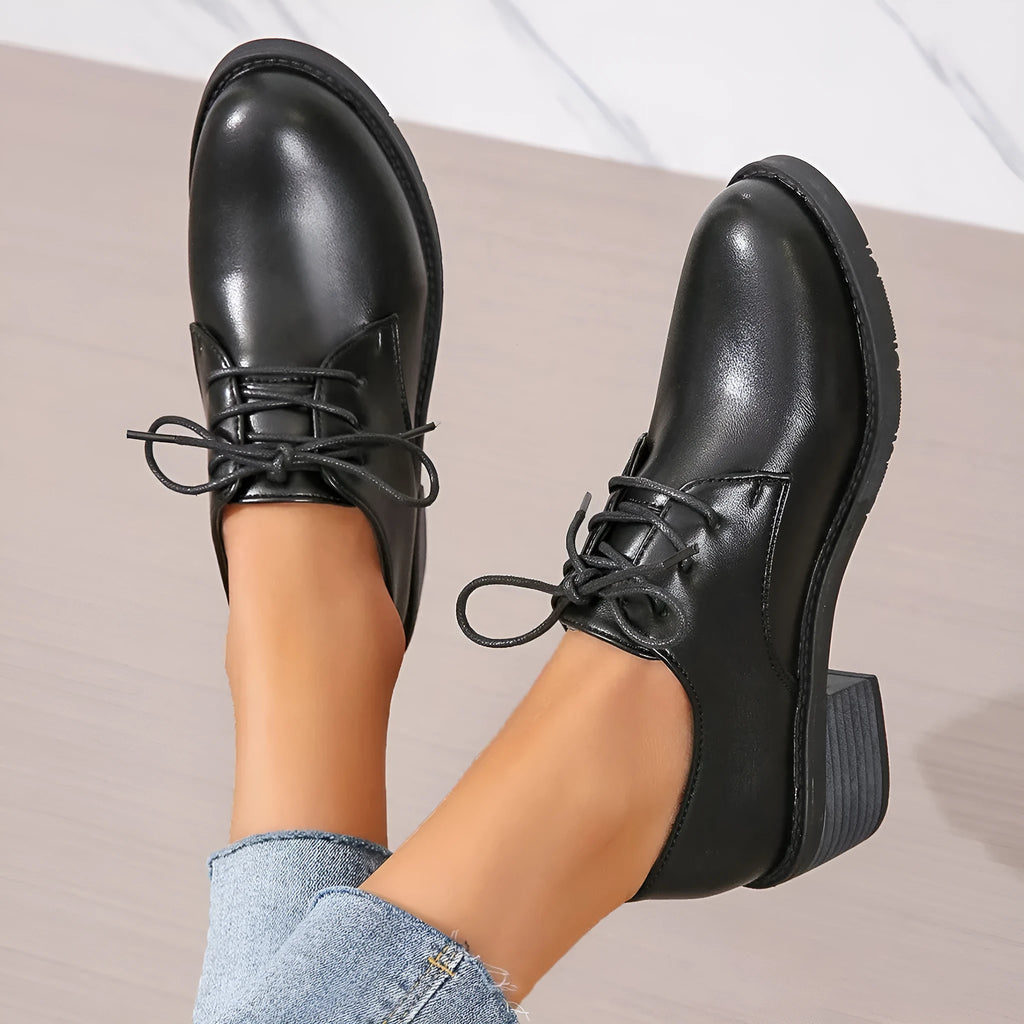 Black women's low-top work shoes with a chunky heel, rounded toe, and soft rubber sole.