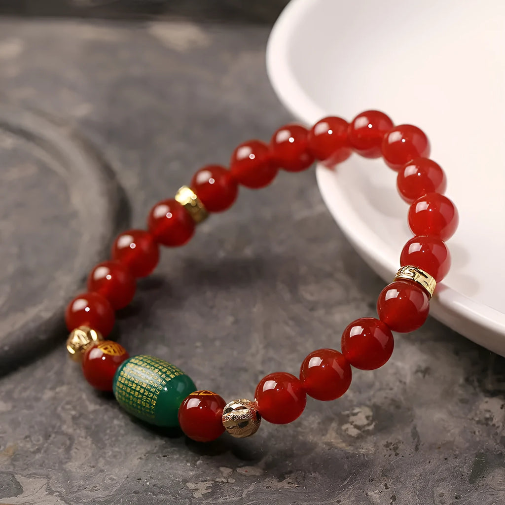 Agate Guanyin prayer bead bracelet in green or red on a wrist, showing auspicious patterns and charm.