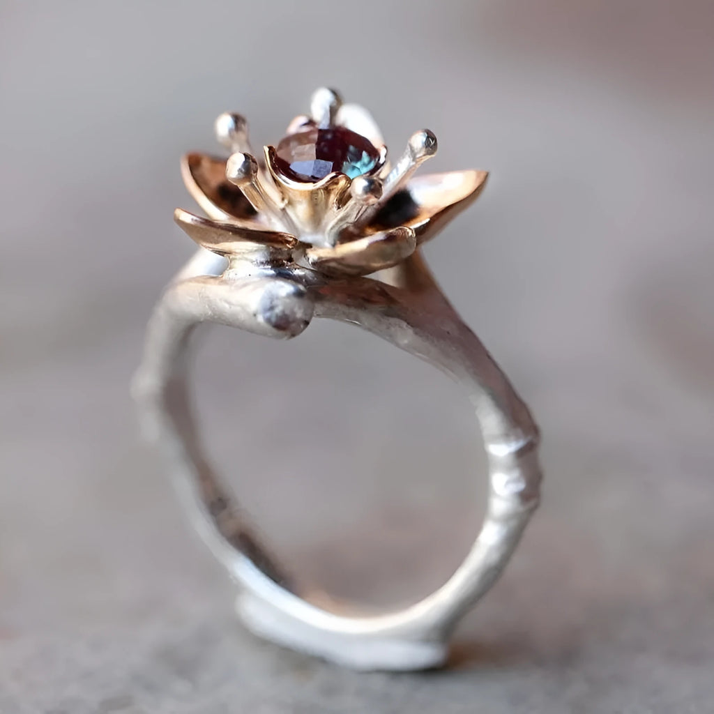 Silver two-tone floral design women's alloy ring on a simple geometric band.
