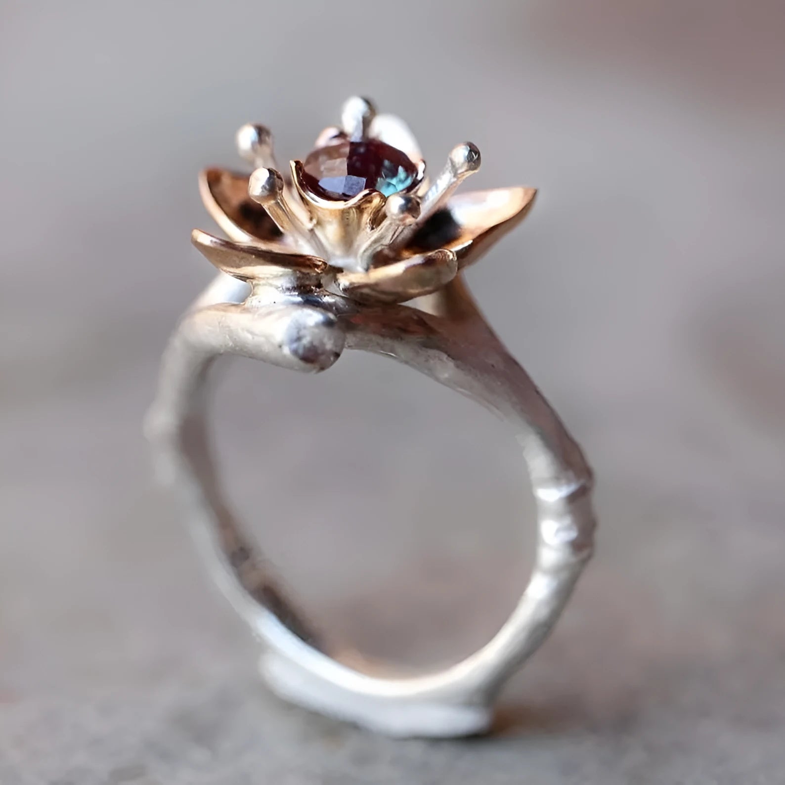 Silver two-tone floral design women's alloy ring on a simple geometric band.