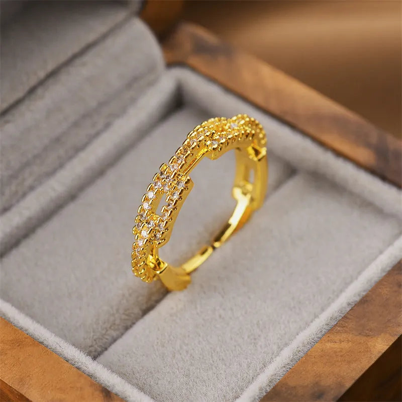 Gold geometric open fashion ring for women on a plain background.