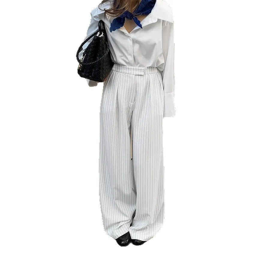 Women's white striped wide-leg trousers with front zipper closure on hanger
