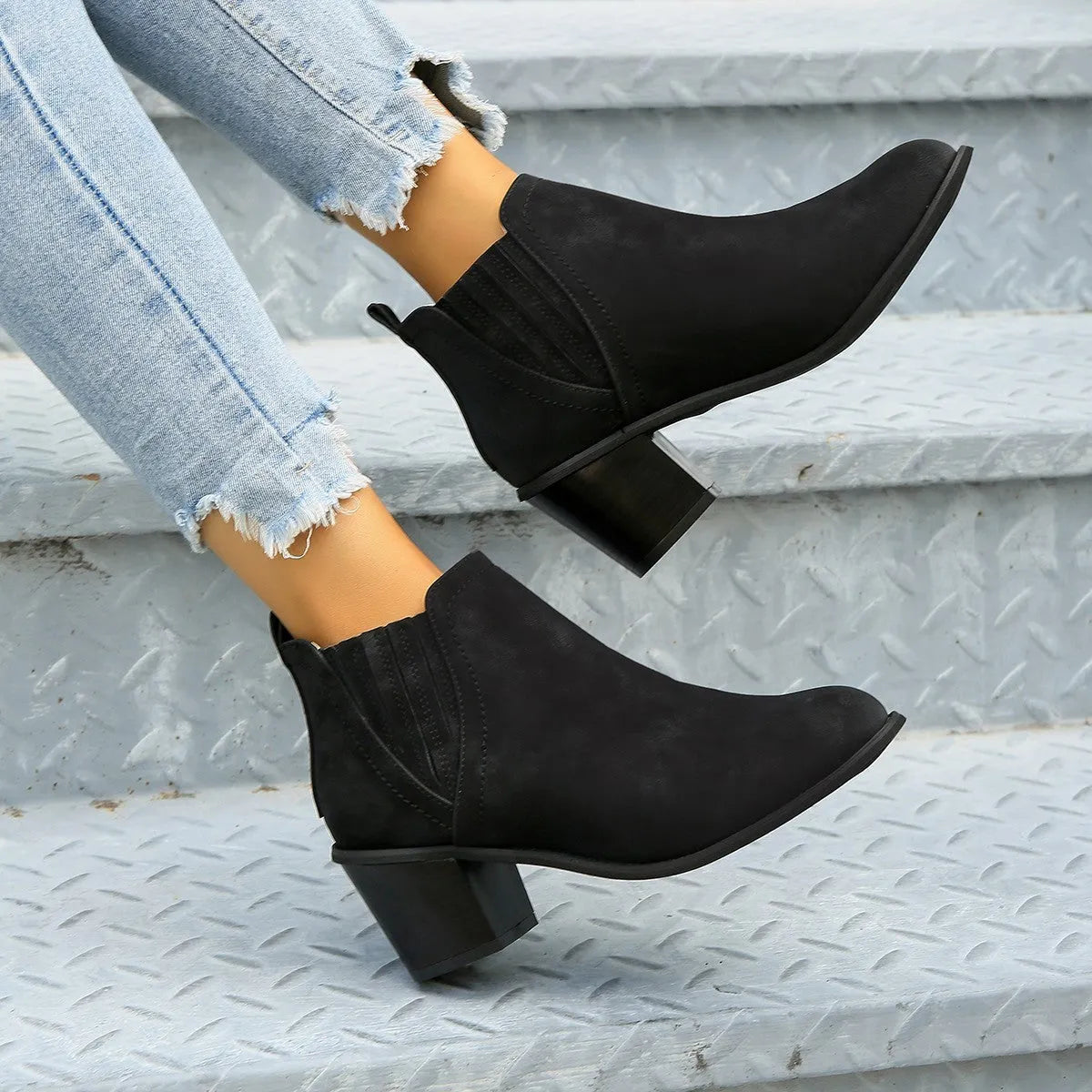 Women's black ankle boots with pointed toe and thick square heel on a rubber sole