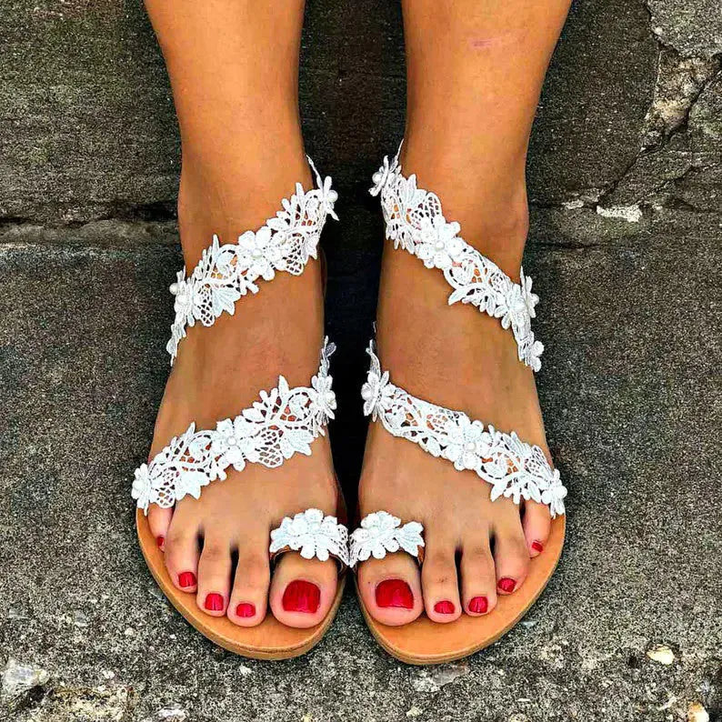 White women's flat sandals with rhinestone flower decoration and patent leather finish