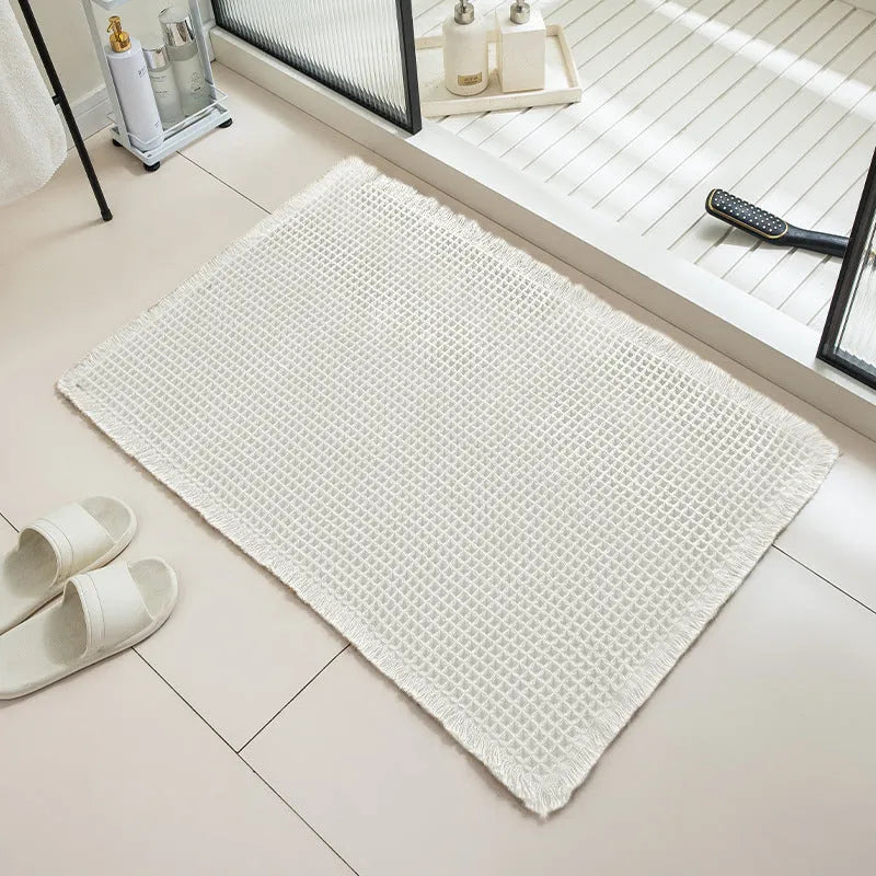 A square, checkered-pattern absorbent bathroom floor mat with a non-slip backing, shown in a neutral colour.