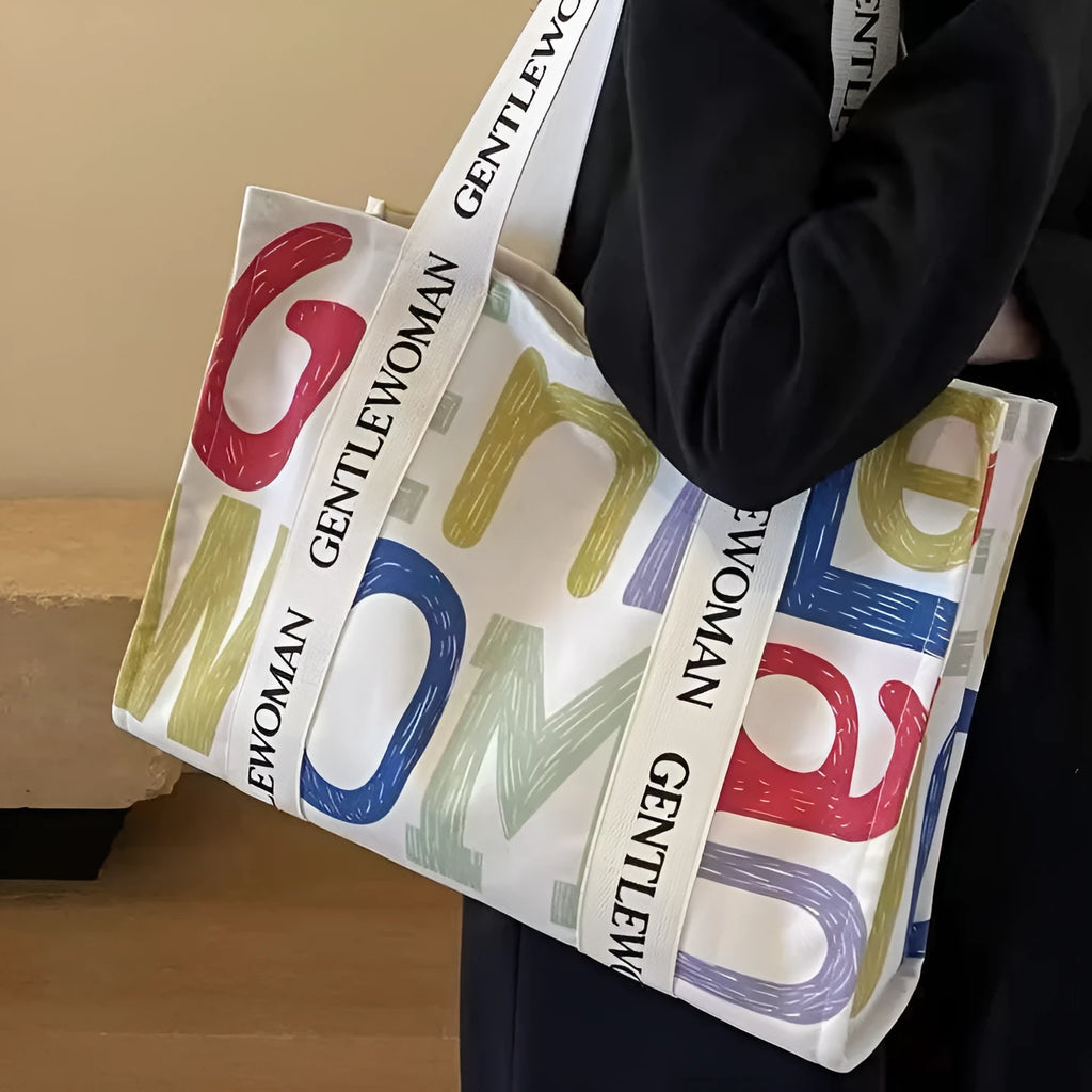 Large canvas tote bag with printed design, featuring two fabric handles, shown in available colour style options.
