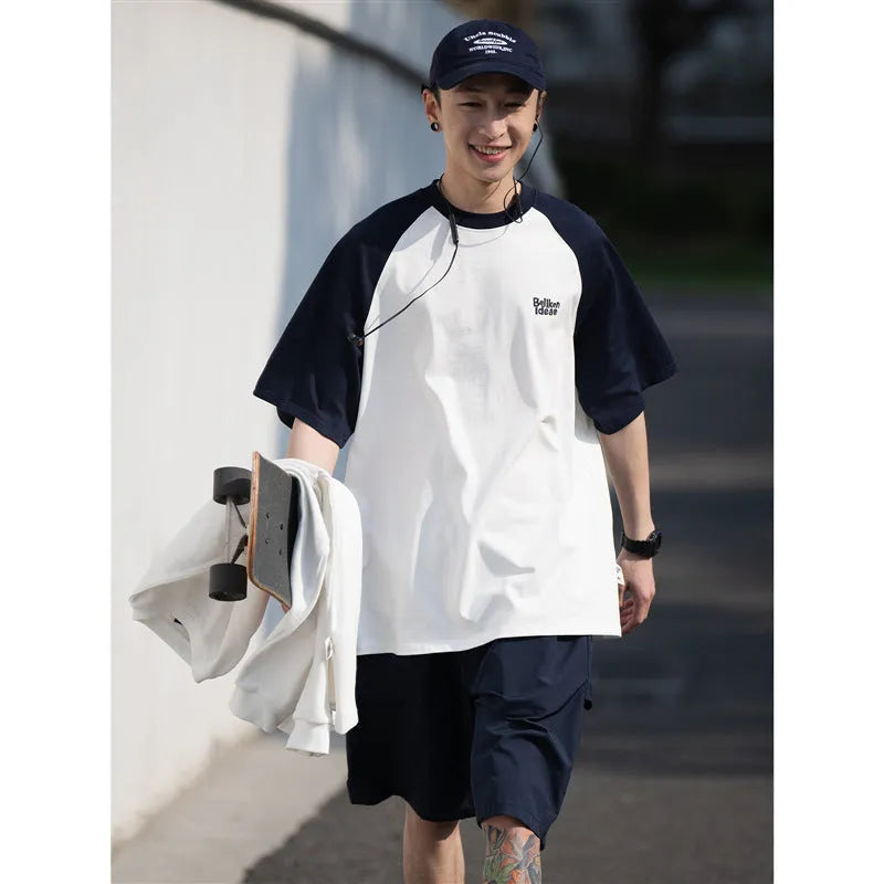 Man wearing a loose blue raglan sleeve casual t-shirt, Japanese style, thin polyester blend.