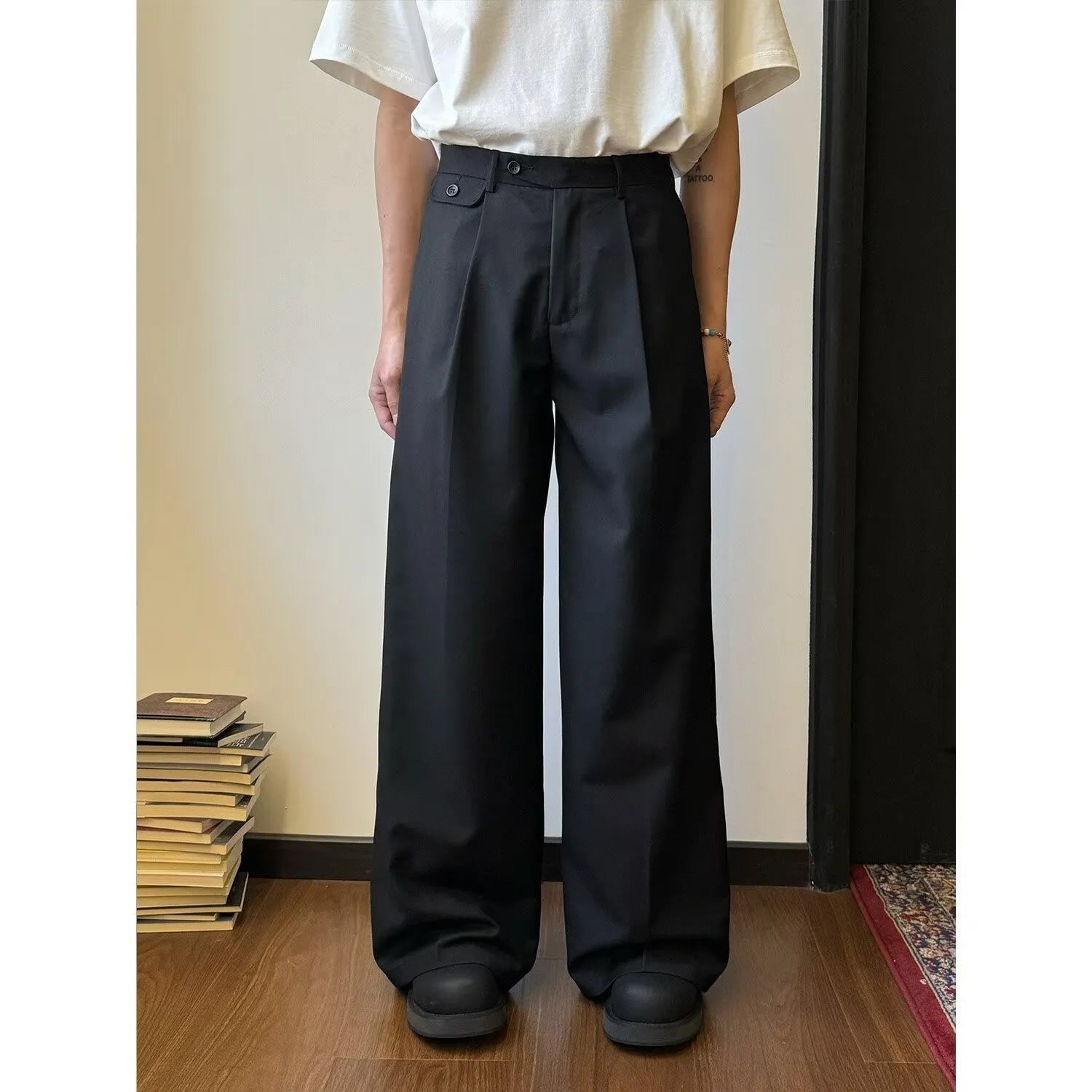 Men's brown straight-leg wide-drape trousers on a hanger, showing loose fit.