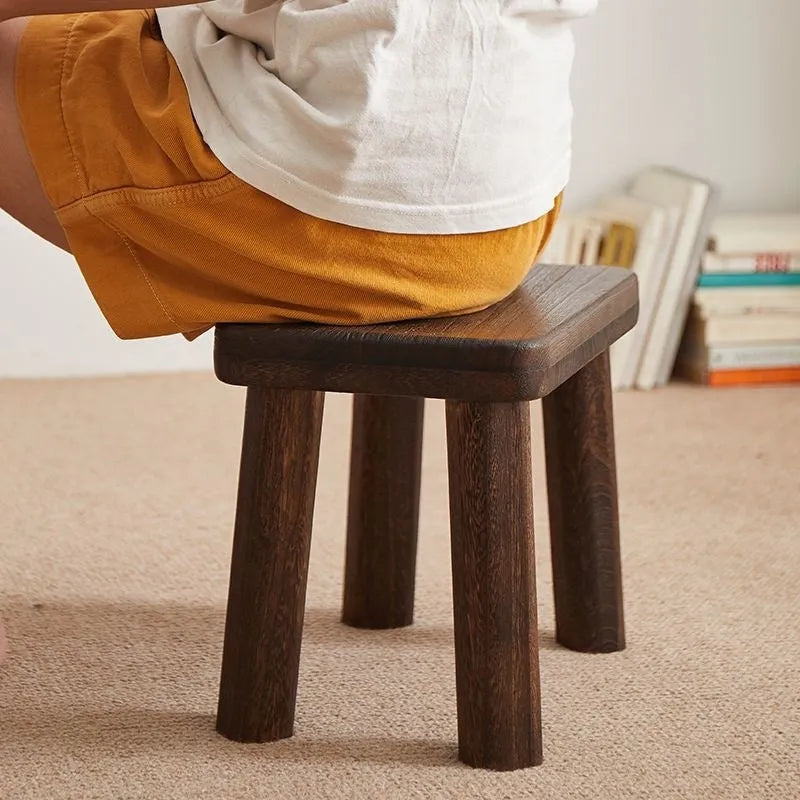 Solid wood distressed finish shoe changing stool with bracket structure for the living room.