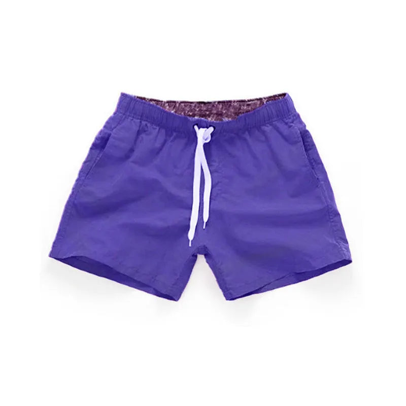 Men's straight-leg beach shorts in polyester fabric on a beach background