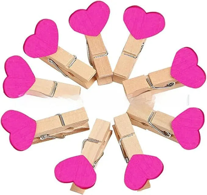 Set of five small wooden heart-shaped hair clips in various colours on a neutral background.