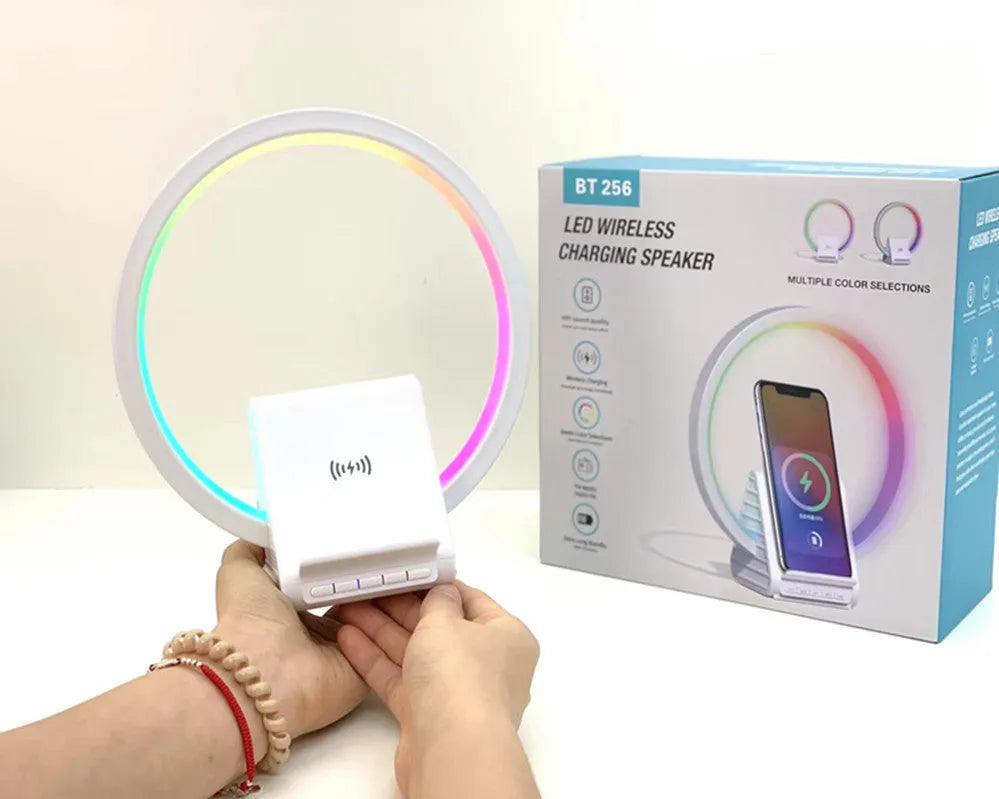 White rectangular smart Bluetooth speaker with integrated wireless charging pad and ambient light on a desk