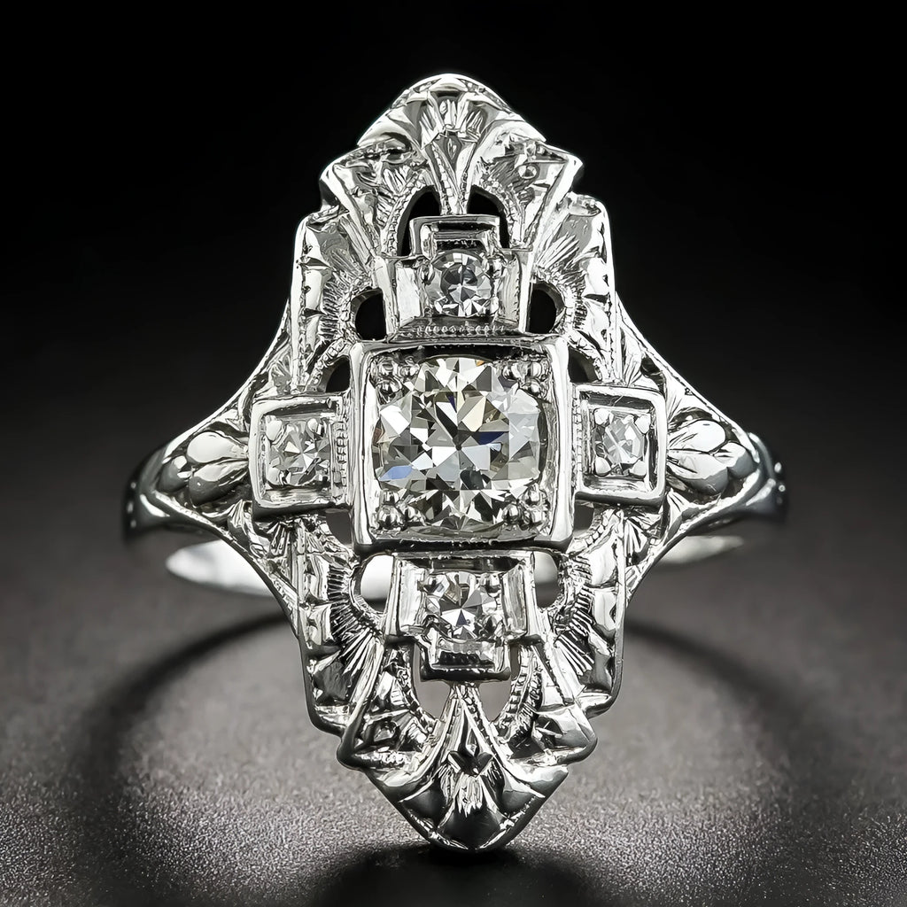 Geometric hollow-out silver ring with diamond studs on a finger.