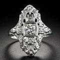 Geometric hollow-out silver ring with diamond studs on a finger.