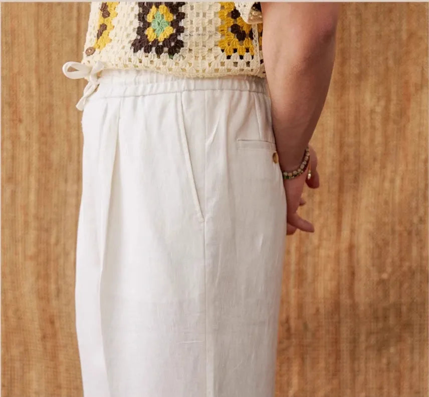 Navy blue linen high-waisted trousers with an elasticated waistband and straight-leg fit on a model.