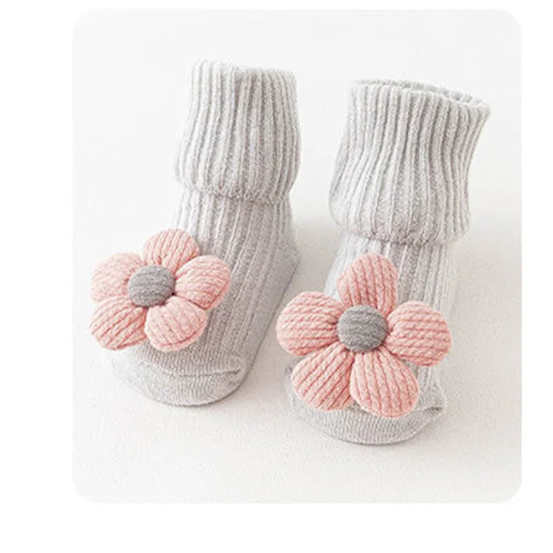 Cotton baby socks in multiple colours and prints including panda, lion, bows, and stars on a white background.