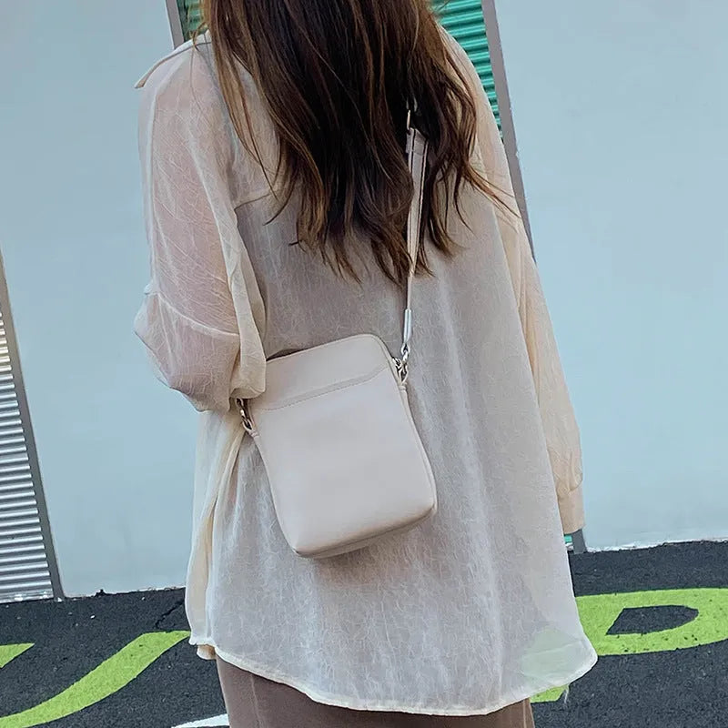 Small solid colour PU leather crossbody bag for women in black, shown with shoulder strap.