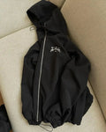 Man wearing a grey loose-fit hooded sunscreen jacket in British style.