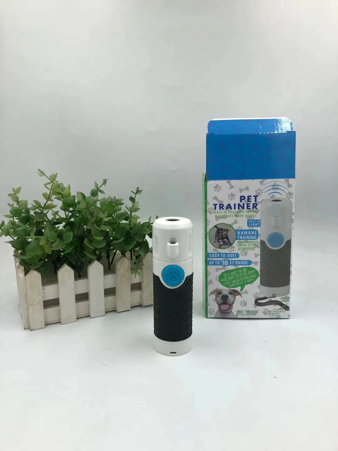 White handheld ultrasonic dog trainer device for bark control on a plain background.