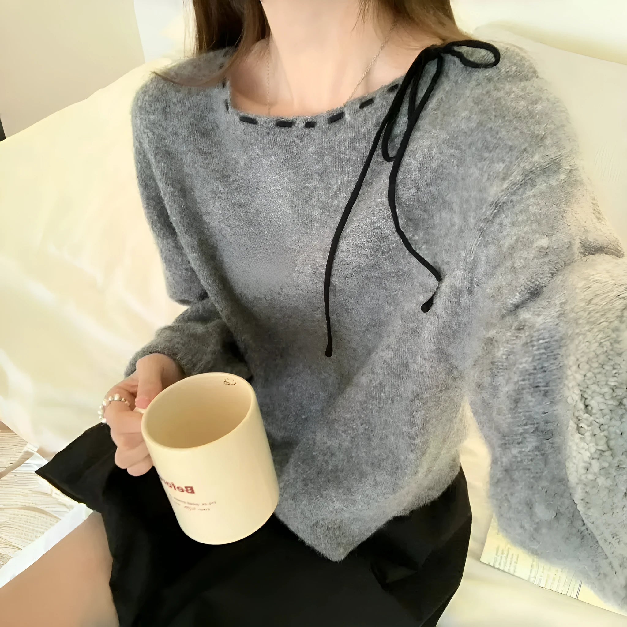 Grey loose-fitting women's long sleeve pullover sweater on a hanger