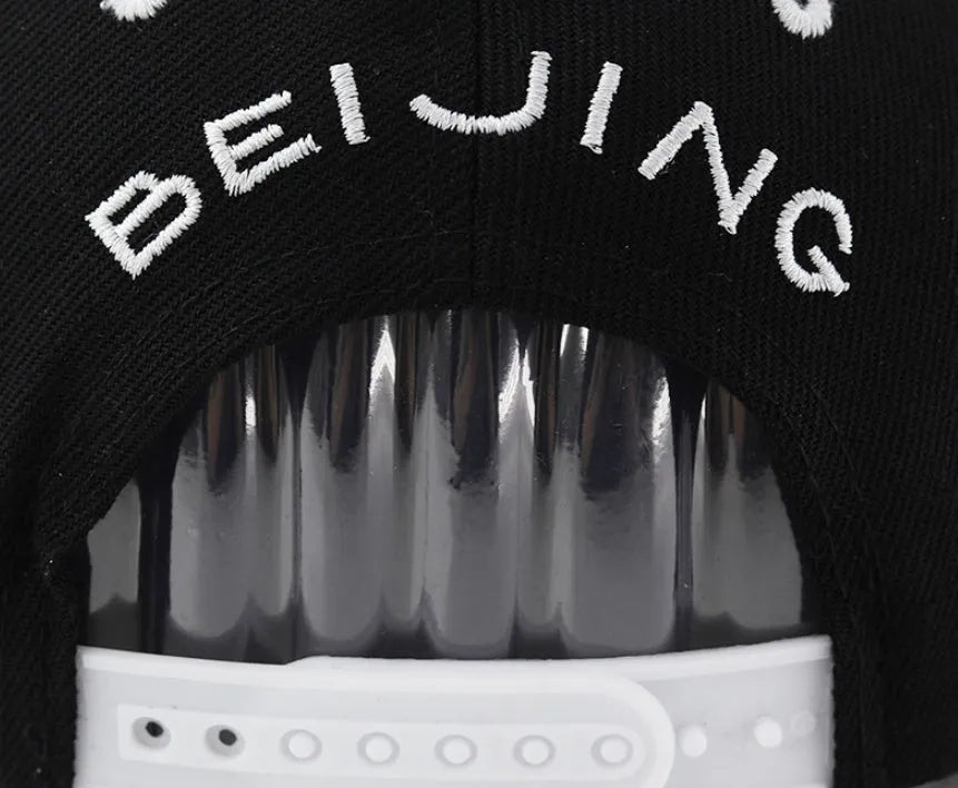 Cotton baseball cap with embroidered lettering in black or white with adjustable strap