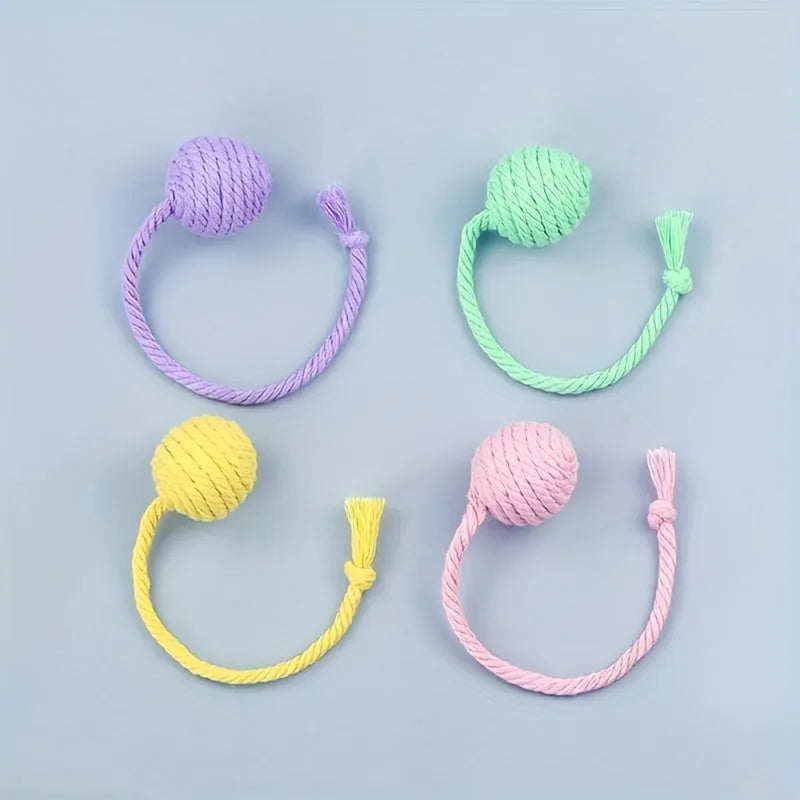 Interactive cat toy ball with rope and internal bell in green, pink, purple and yellow colours