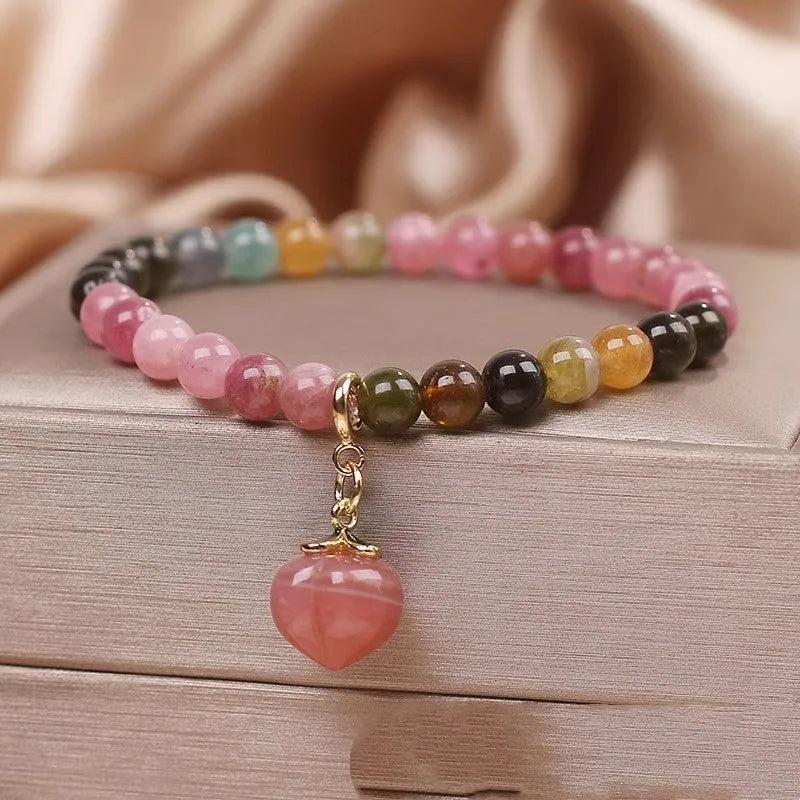 Natural rainbow tourmaline single-circle bracelet with agate peach pendant on wrist