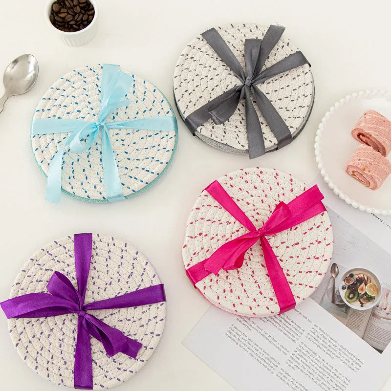 Set of three round grey cotton cord coasters, each 18 cm in diameter, on a wooden table.