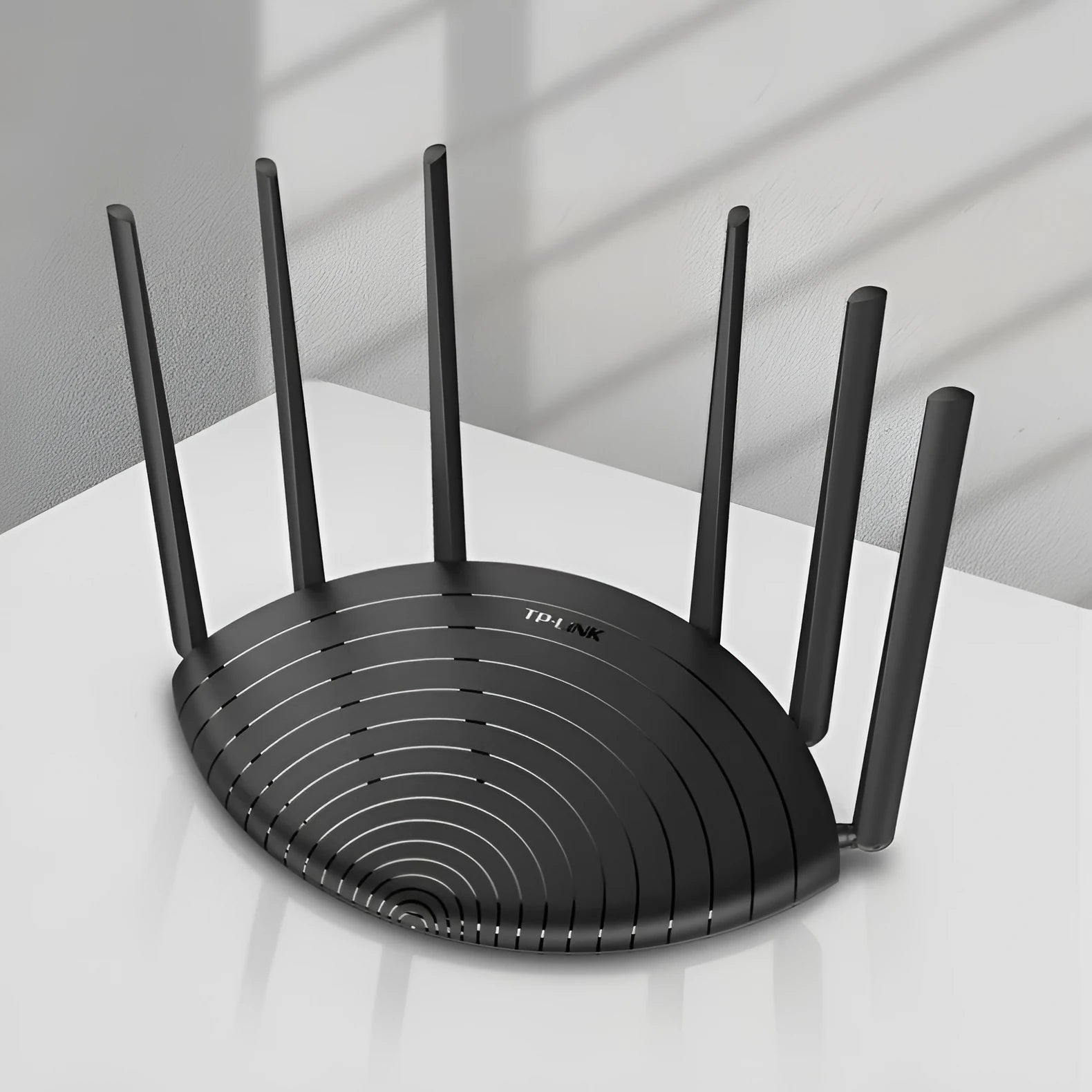 TP-Link TL-WDR7661 AC1900 Gigabit wireless router in black housing on a desk.