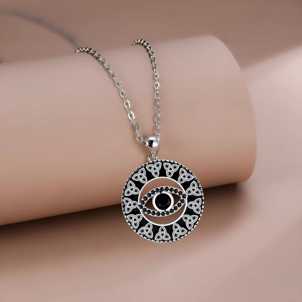 Close-up of a copper Devil's Eye pendant necklace with an electroplated finish on a matching cross chain.