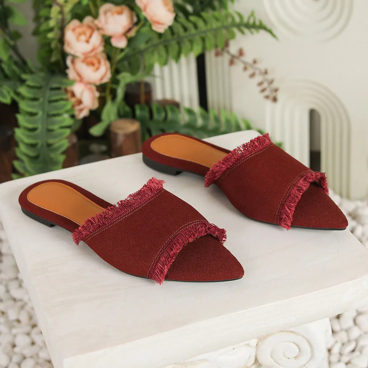 Women's denim flat slippers with a tassel decoration and leather lining in multiple colour options.